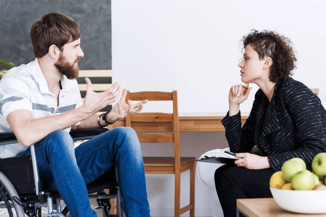 Therapist discussing with disabled patient (1)